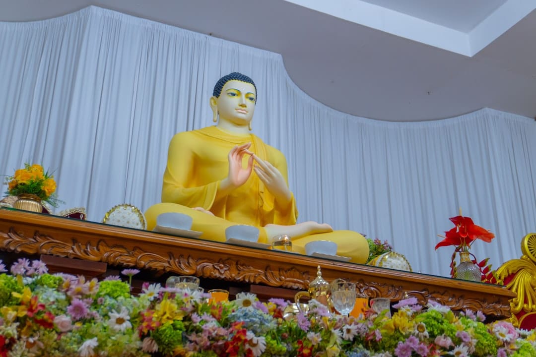 a buddha statue sitting on top of a wooden table